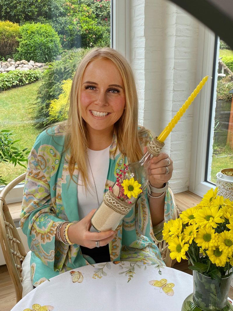 Katharina mit Kerzenhalter aus Weinflasche in der Hand